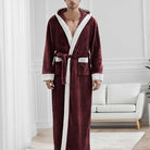 Homme portant le peignoir Étienne, modèle chaud et idéal pour l’hiver en tissu bordeaux doux avec bordures crème et ceinture assortie, présenté dans un intérieur moderne et lumineux.