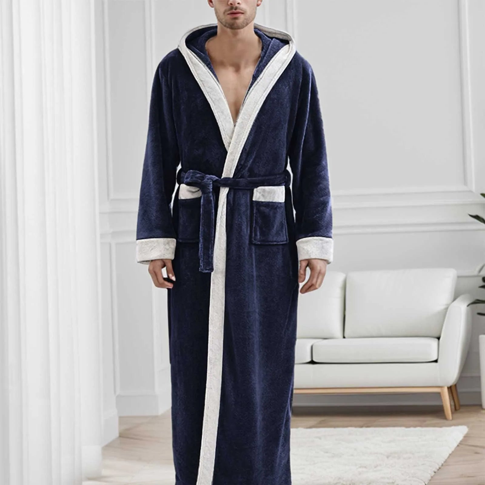 Homme portant le peignoir Étienne, modèle chaud et idéal pour l’hiver en tissu bleu marine doux avec bordures crème et ceinture assortie, présenté dans un intérieur moderne et lumineux.